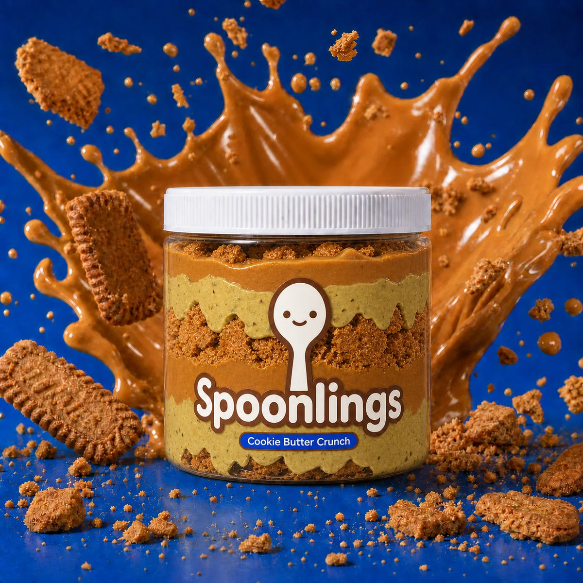 Cookie Butter Crunch jar against cobalt blue with cookie butter and biscuit pieces in motion
